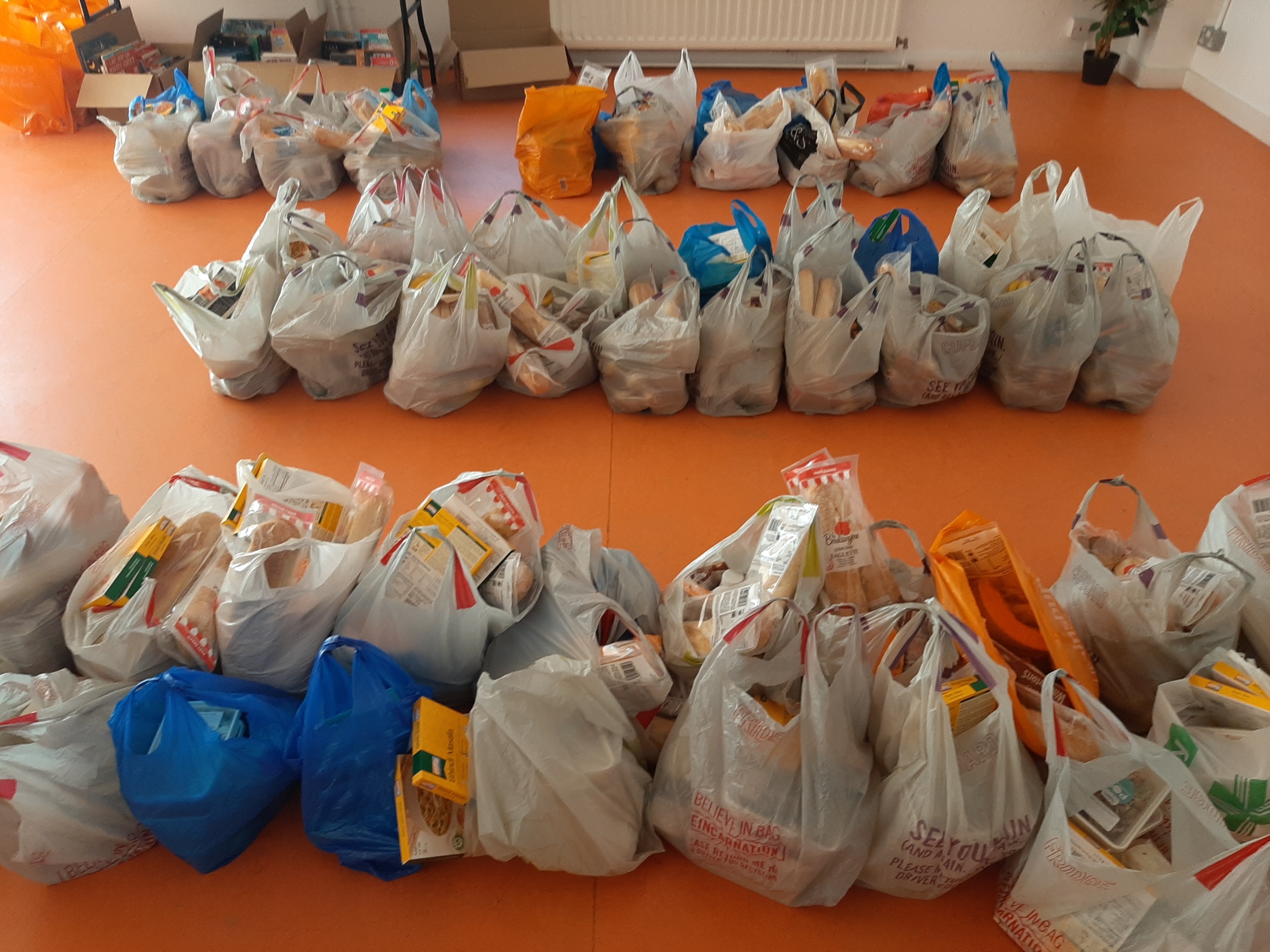 The image shows bags of food distributed through Granville Community Kitchen's Food Aid Programme